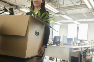 Young businesswoman moving box with office supplies